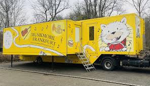 Musikmobil Frankfurt – gelber Anhänger mit Instrumenten-Illustrationen