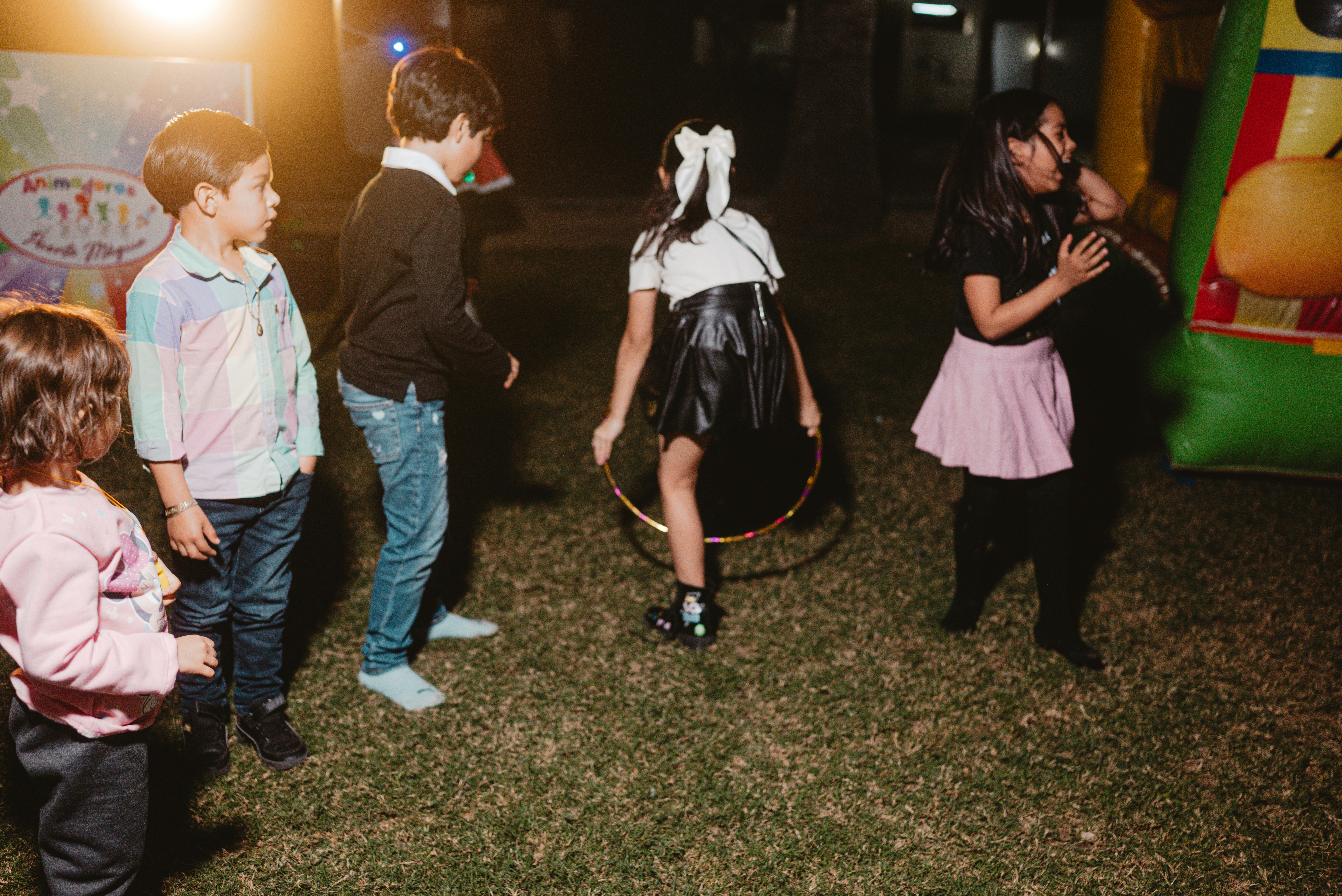 Kinder beim Hula-Hoop-Spiel am Abend